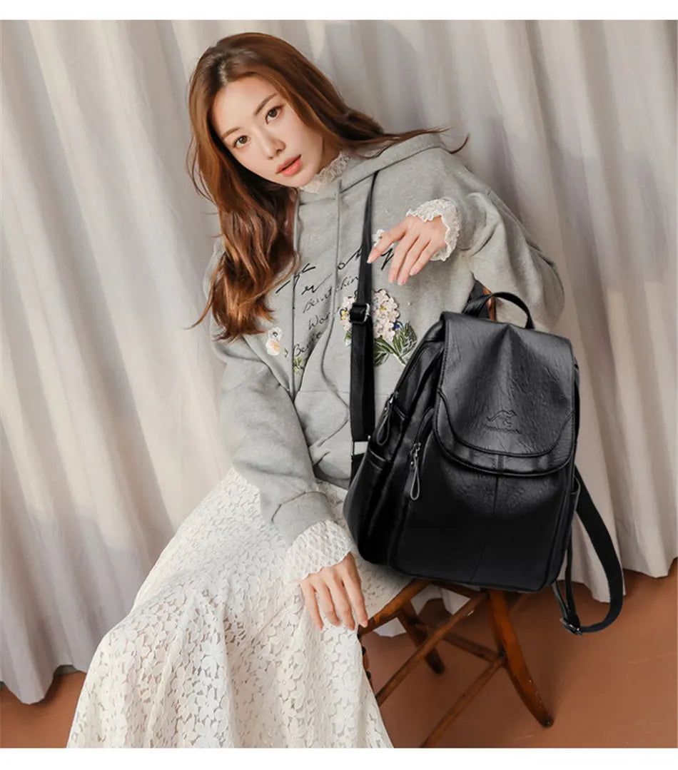 Black leather backpack on a seated model