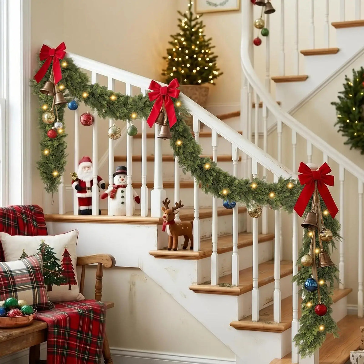 Lighted cedar garland on a staircase with red bows