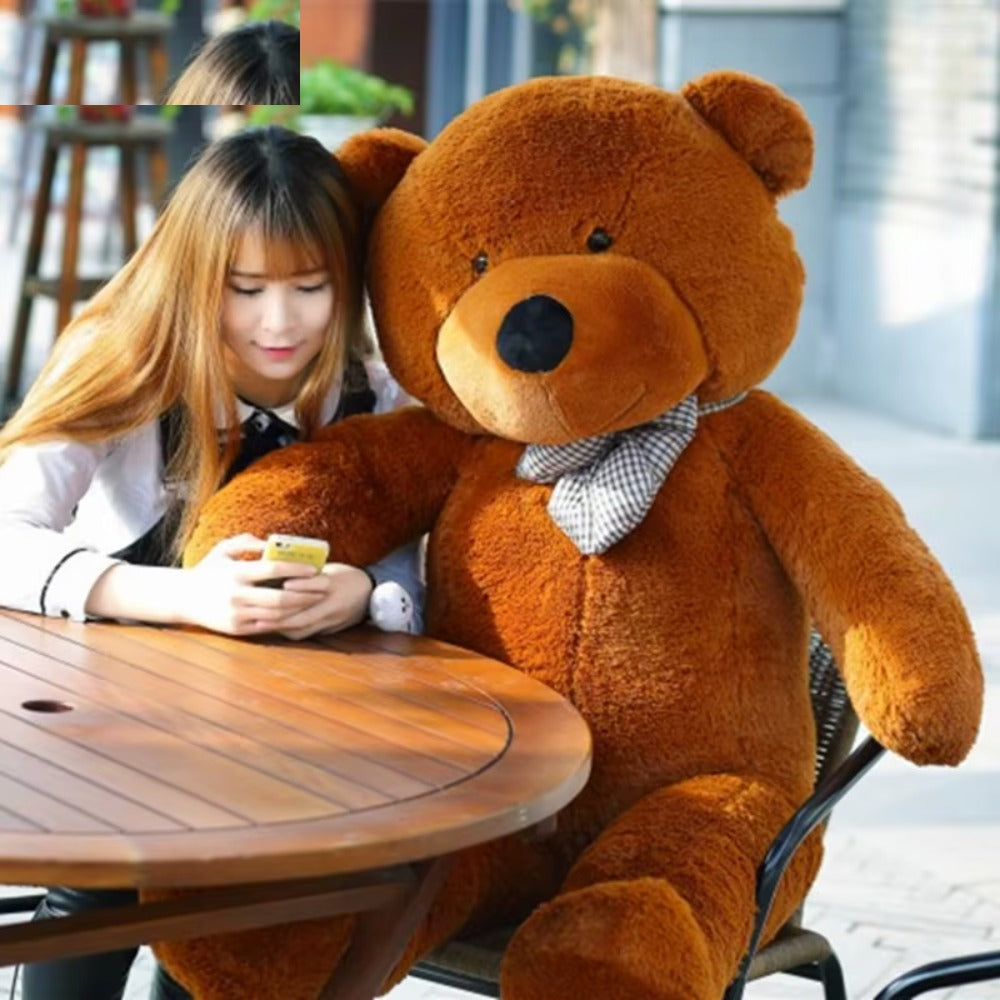 Giant dark brown teddy bear sitting at a table