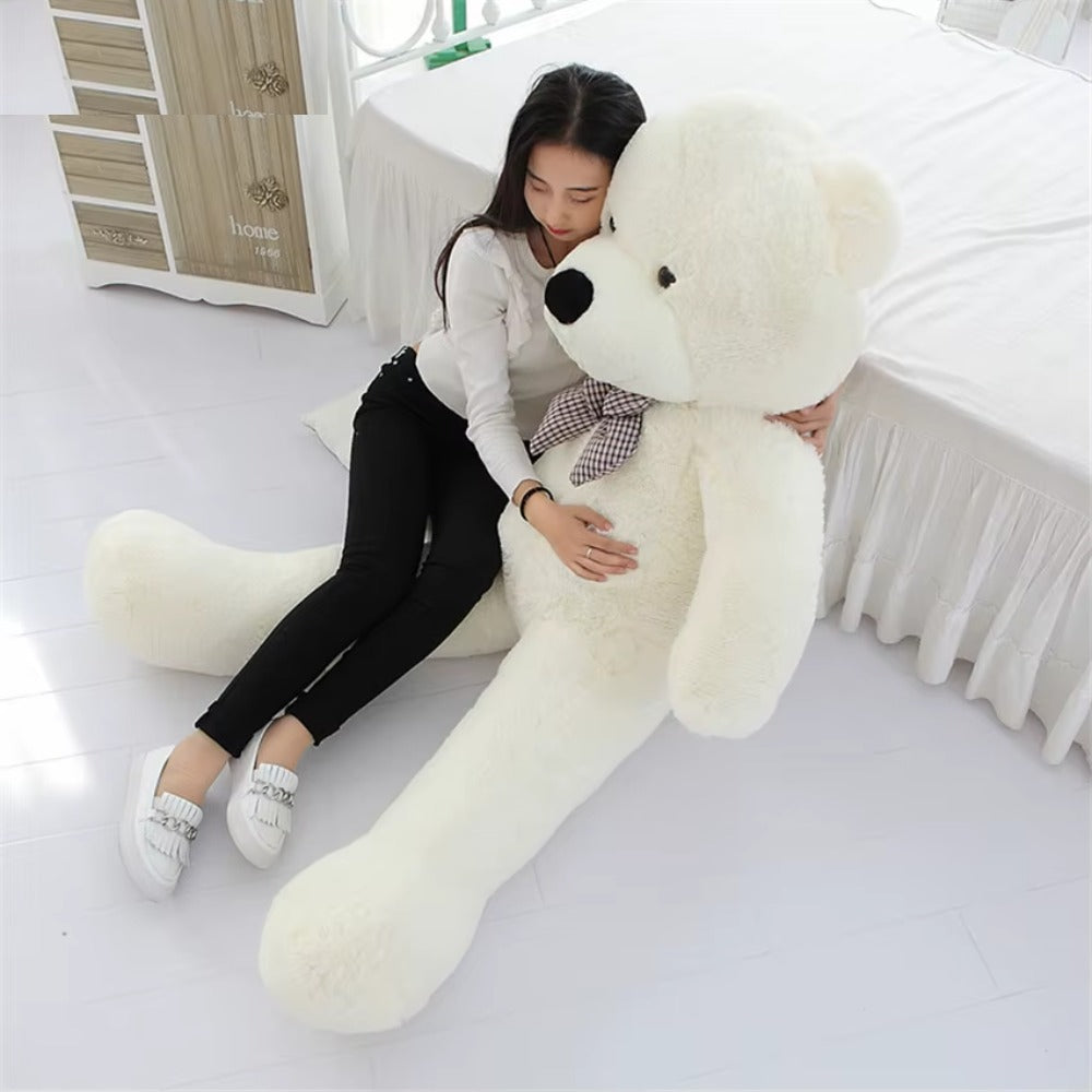 Woman lying against a giant white teddy bear